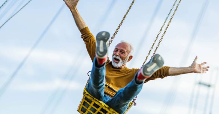 Zorgeloze volwassen man met plezier in een draaimolen